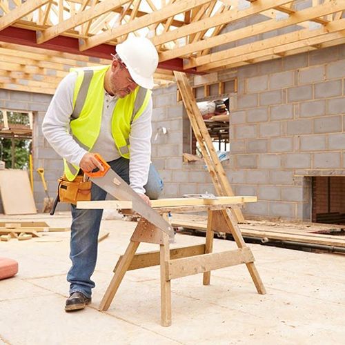 Carpenter cutting roof timber