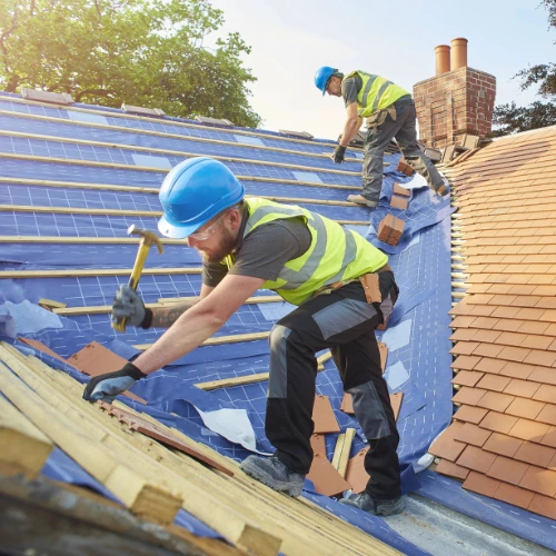 Roof carpenters installing new roof tiles
