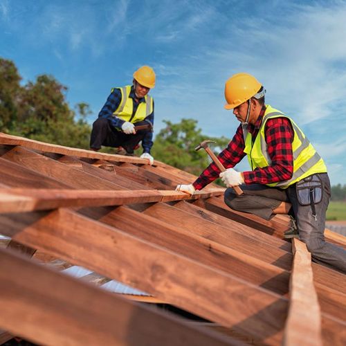 Workers installing wooden roof framing